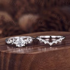 two wedding rings sitting on top of a wooden table