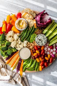 a platter filled with vegetables and dips