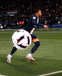 a man kicking a soccer ball on top of a field