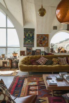 a living room filled with lots of furniture and large round windows over looking the ocean