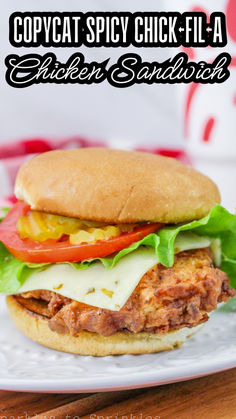 a chicken sandwich with lettuce, tomato and cheese on a white plate that says copycat spicy chick - fla chicken sandwiches