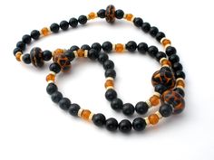 Vintage Beaded Jewelry - This is a stylish black onyx bead necklace with amber art glass and gold plated spacers. It is 28" long, gemstones are .38" (10mm) and the art glass beads are slightly over .75 (29mm), weighs 111 grams. Onyx Bead, Bead Necklace, Black Onyx, Art Glass, Onyx, Beaded Jewelry, Glass Art, Glass Beads, Amber