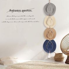 a room with a bed, chair and wall hangings on the wall that says autumn quotes