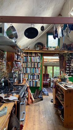 a kitchen filled with lots of clutter and cooking utensils on top of a wooden floor