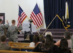 two soldiers giving a speech in front of an audience