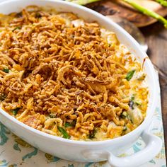 a casserole dish with noodles and vegetables in it sitting on a floral napkin