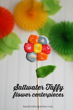 a close up of a candy flower on a stick with the words saltwater taffy power centerpieces