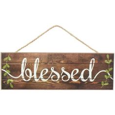 a wooden sign that says,'blessed'hanging from a rope on a white wall