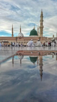 two men sitting on the ground in front of a mosque