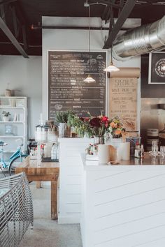 the interior of a coffee shop with tables and chairs in front of it, along with menus on the wall