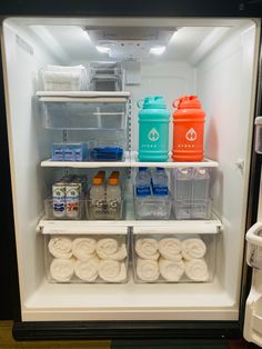 an open refrigerator filled with lots of different types of drinks and food in plastic containers