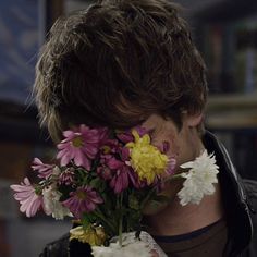 a man with flowers in his mouth