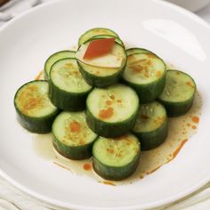 cucumbers are arranged on a white plate with sauce