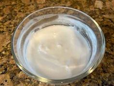 a glass bowl filled with white liquid on top of a counter