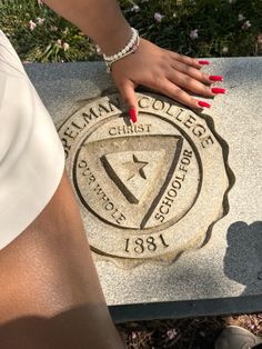 a woman's hand on the emblem of a college