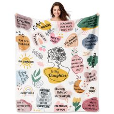 a woman is holding up a large blanket with words and flowers on it that say i'm my daughter