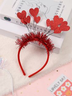 a red headband with hearts on it and some hair pins in the shape of heart