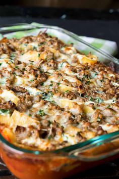 a casserole dish with meat and cheese in it sitting on a checkered cloth