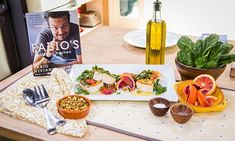 a table topped with plates and bowls filled with food next to a bottle of wine