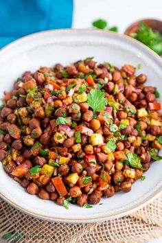 a white bowl filled with beans and cilantro garnished with parsley