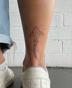 a woman's foot with a tattoo design on the side of her left leg