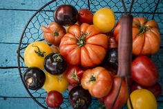 a basket filled with lots of different types of tomatoes