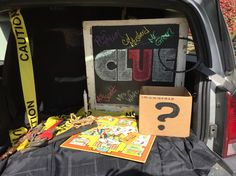 the back end of a car with various items in the trunk, including a sign that says do you know?