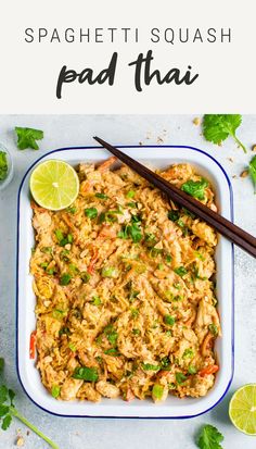 an overhead view of pad thai rice with chopsticks and lime on the side