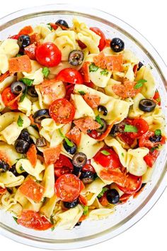 a bowl filled with pasta and olives on top of a table