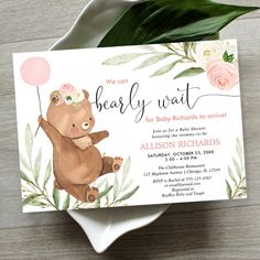 a baby shower card with a teddy bear holding a pink balloon and flowers on it