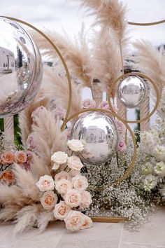 an arrangement of flowers and mirrors on the ground