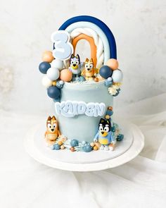 a birthday cake decorated with animals and balloons