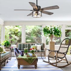 a living room filled with furniture and a ceiling fan in the middle of it's walls