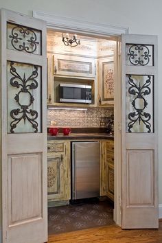 an open door leading into a kitchen with wood floors