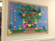 a child's artwork hangs on the wall in front of a classroom sign that reads,