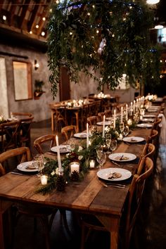 a long table with candles and greenery is set up for an elegant dinner party