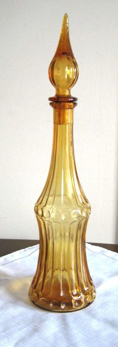 a yellow glass bottle sitting on top of a table