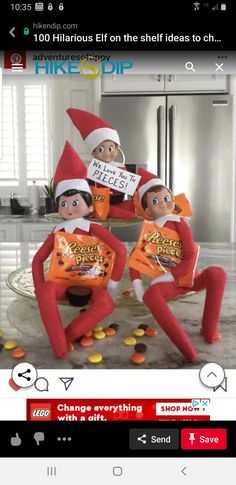 three elfs sitting on top of a table with candy bars in front of them