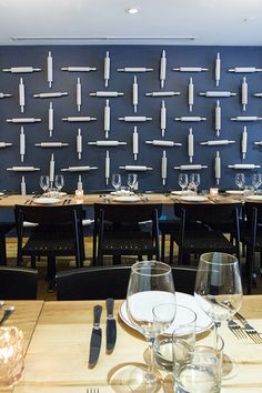 an empty restaurant table with place settings and wine glasses on the tables in front of it