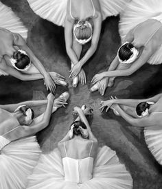 six ballerinas in white tutu skirts with their hands together