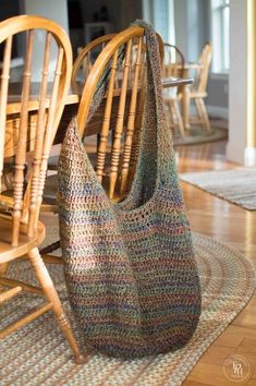 a crocheted bag sitting on top of a rug next to a wooden table