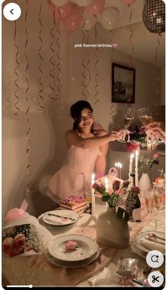 a woman sitting at a table with plates and candles