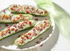 several stuffed green peppers on a plate with bacon, cheese and seasoning sprinkles