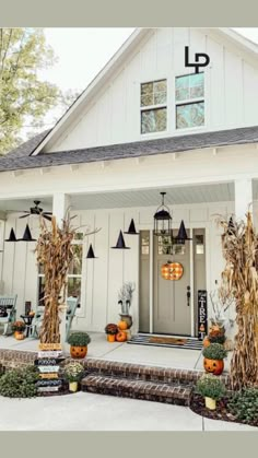 a white house with pumpkins on the front porch