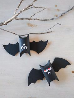 two paper bats with faces and eyes on them