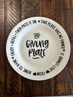 a white plate with the words giving plate on it sitting on a wooden table top