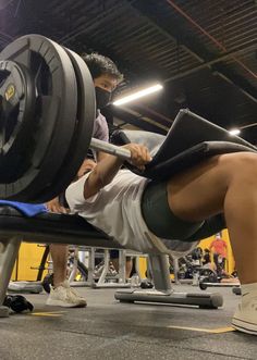 a man is doing a bench press in the gym