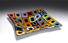 a square shaped glass plate with multicolored squares on it