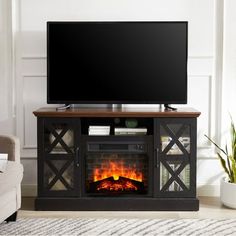 a flat screen tv sitting on top of a wooden stand next to a fire place