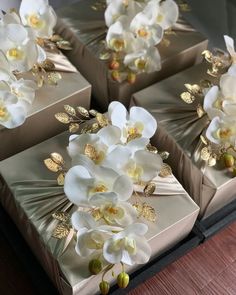 four boxes with white flowers on them sitting on a table